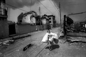 Knut Mueller, "Kosovo - Plünderungsszene im niedergebrannten Roma-Viertel von Mitrovica", 1999