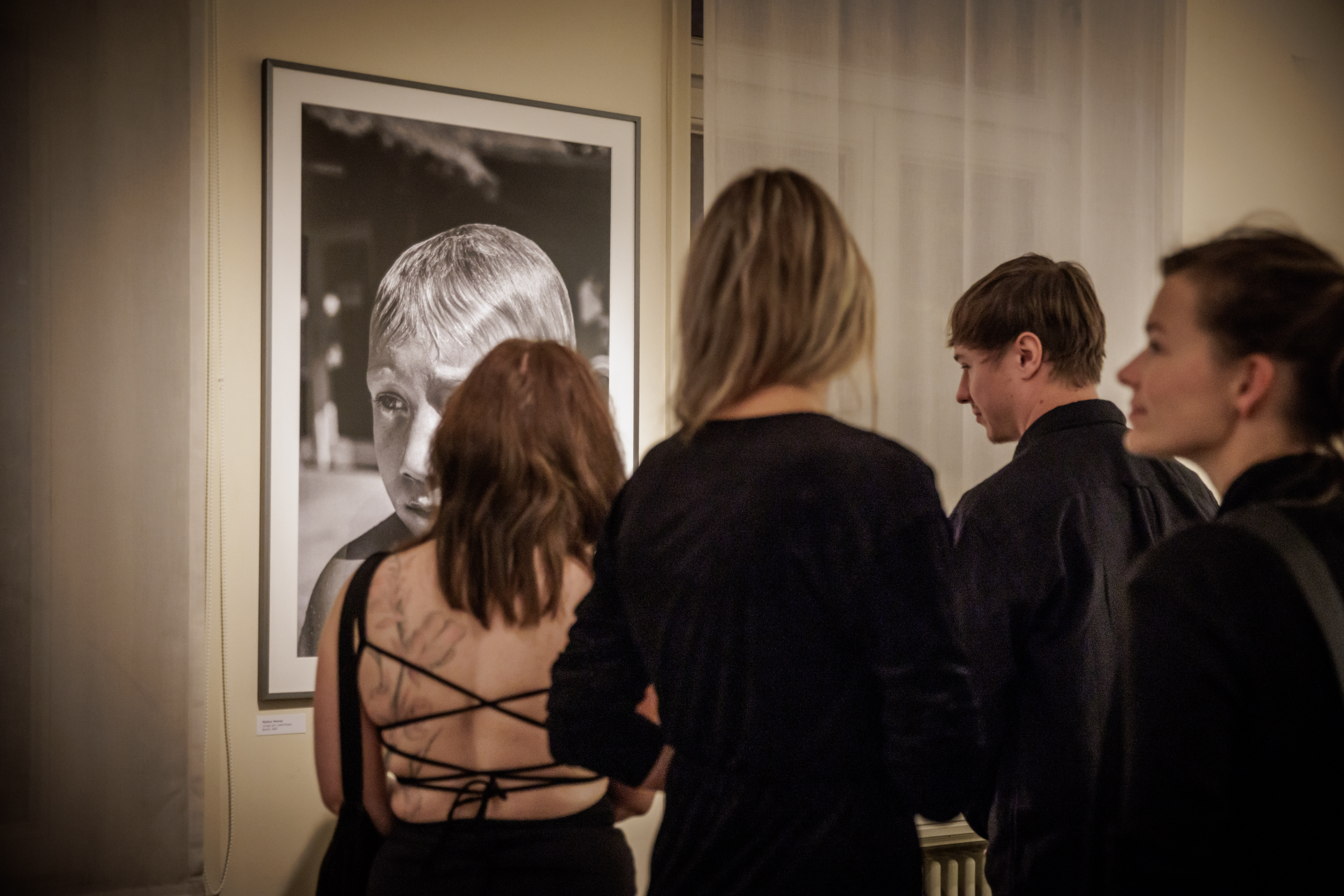 Ausstellungsbesucher stehen vor einem Foto von Marcus Werner